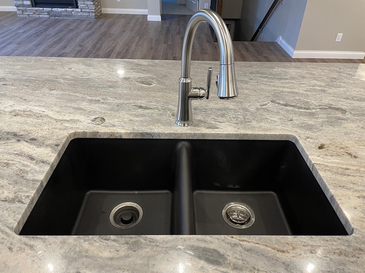 Black split sink with stainless steel faucet.